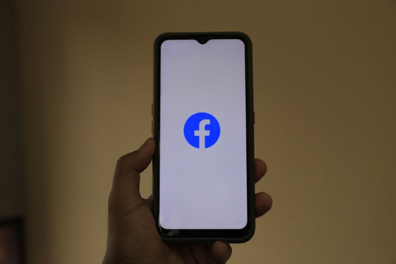 Читатель проверяет достоверность публикации в социальной сети на смартфоне