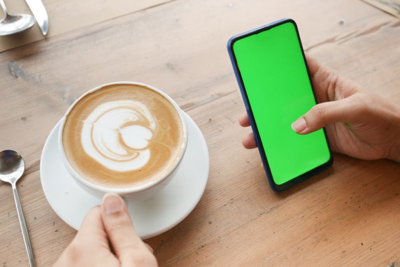 Человек проверяет источник новости на экране смартфона